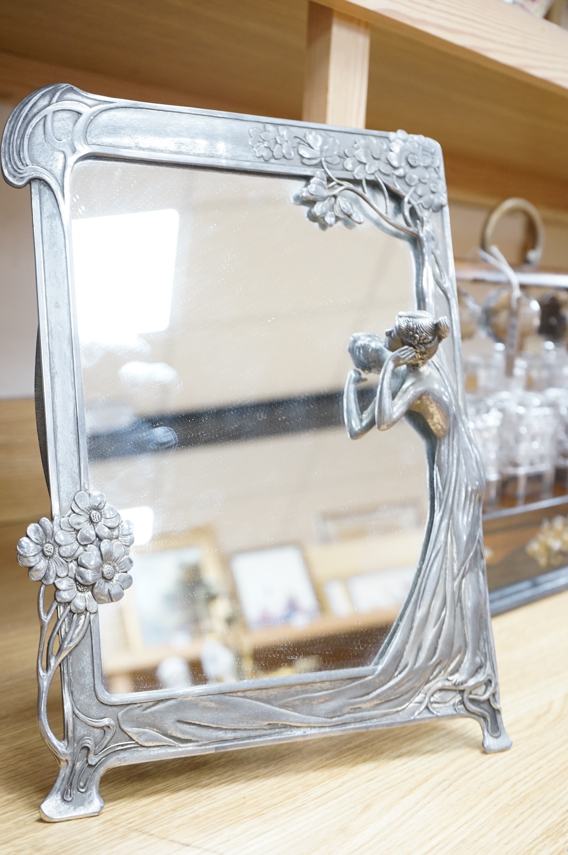 A WMF style metal mounted and engraved glass claret jug and a later figural easel mirror, tallest mirror 36cm.